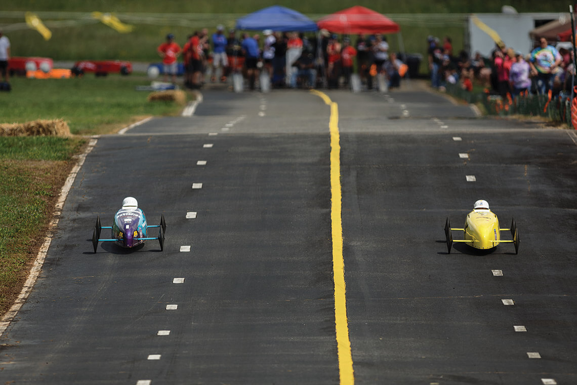 Two racers speed across the track at the Morganton Soap Box Derby