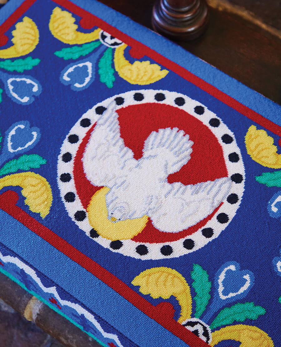 Needle stitched kneeler showing a dove surrounded by a circle 