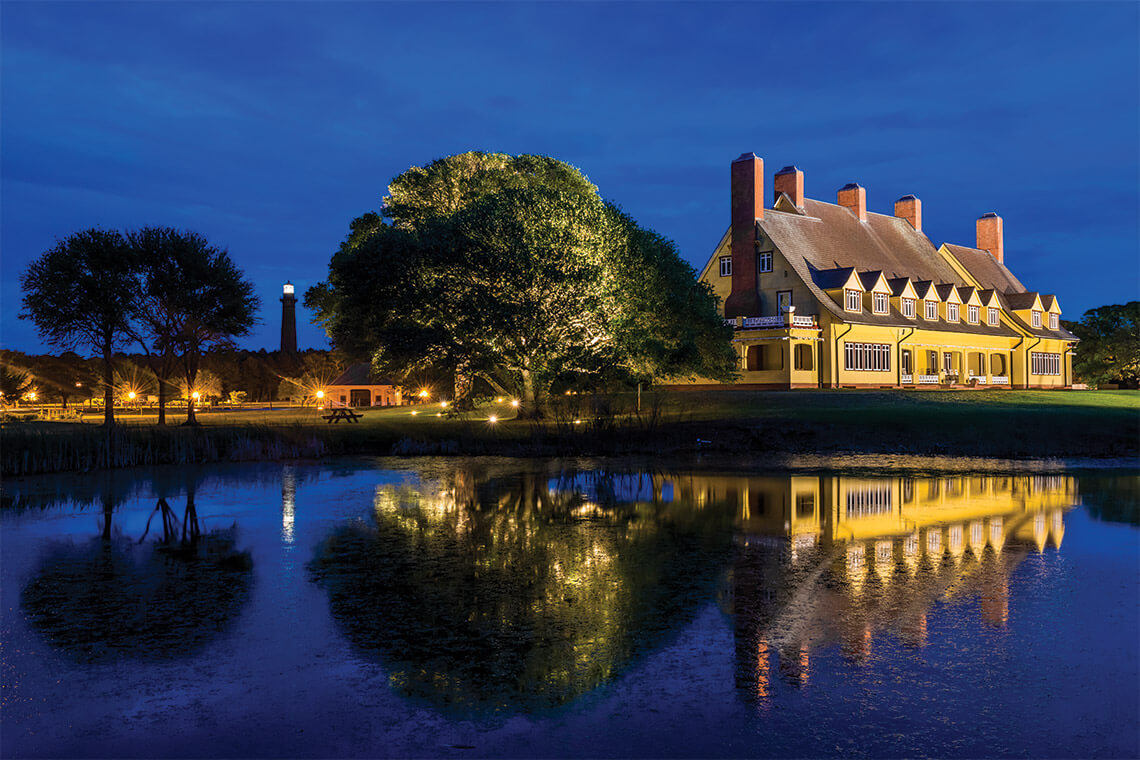 At night, the Currituck Beach Lighthouse illuminates Historic Corolla Park, which includes Whalehead Club
