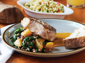 Grilled pork chop, succotash in the background at The Herringbone on the Waterfront