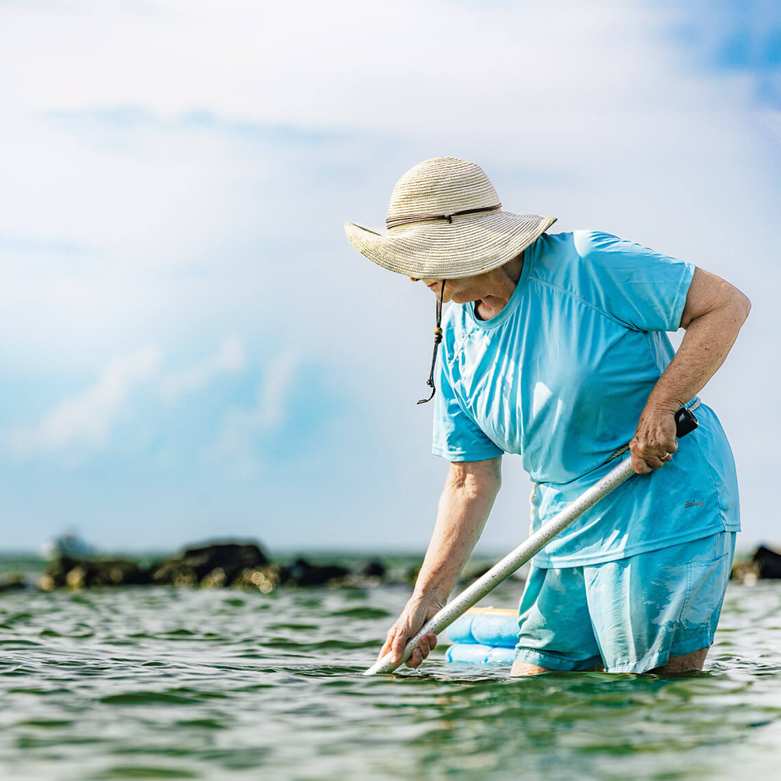 Ruth Toth rakes for clams in the shallow waters of Pamlico Sound