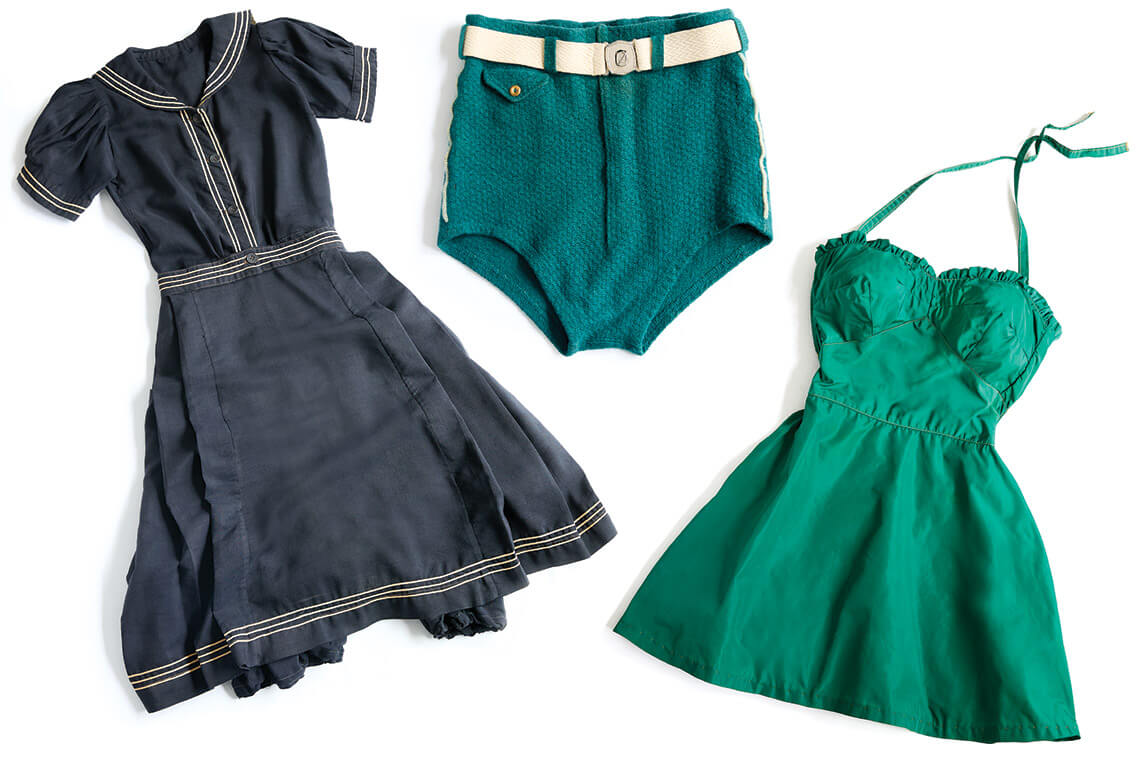 Turn-of-the-century swimsuits including a navy wool dress, wool-knit briefs, and a hunter green silk taffeta suit