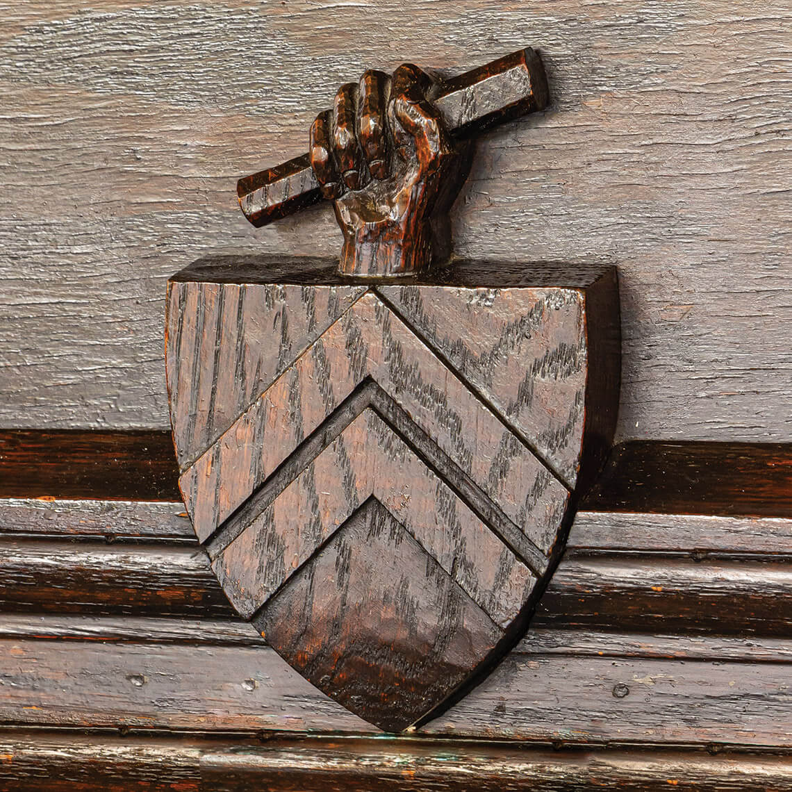 Wood carving over the fireplace of a diploma and family crest