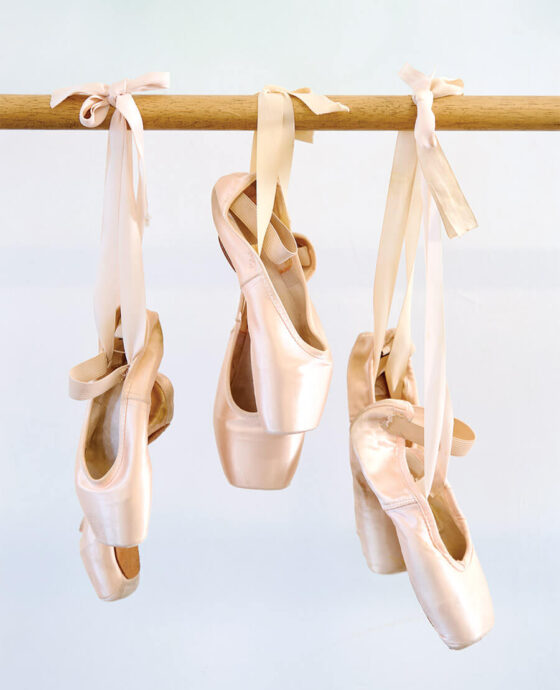 Pointe ballet slippers hang from a barre at Louis Nunnery School of Ballet in Hickory NC