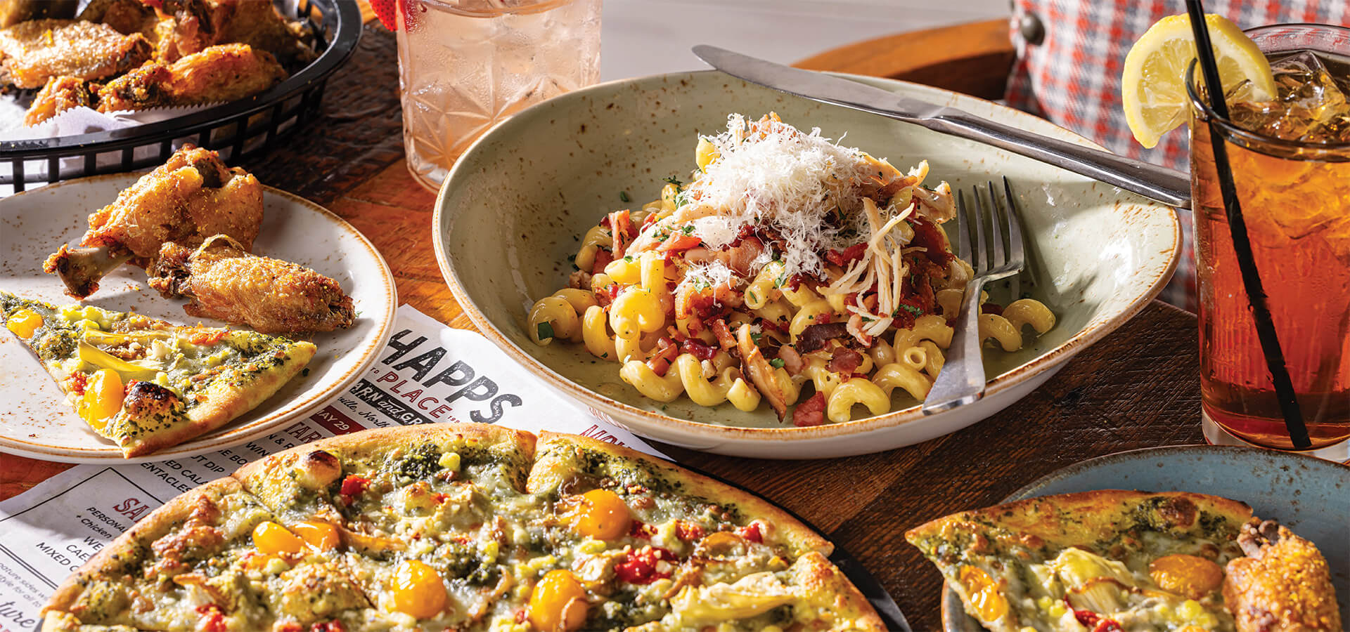 A strawberry-infused cocktail, chicken-bacon-ranch pasta, a Mountain of Veg pizza, and lemon pepper wings at Happs Place Barn and Grill.