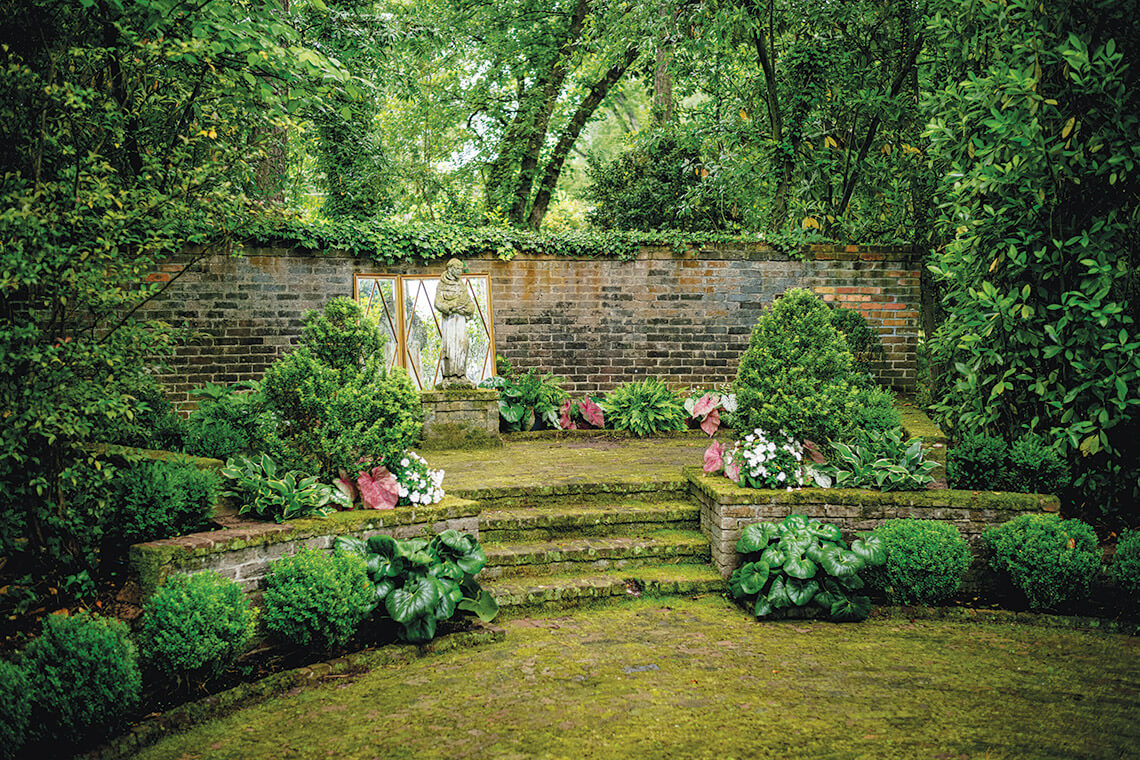 The restored grounds of the Woodards' gardens, including grass-covered steps and a brick wall.