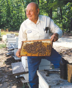 The late beekeeper Brady Mullinax shows off a tray from his hive 