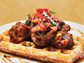 Chettinad-style chicken and dosa waffle, which features masala-coated fried chicken and toasted chili-jaggery syrup at Cheeni.