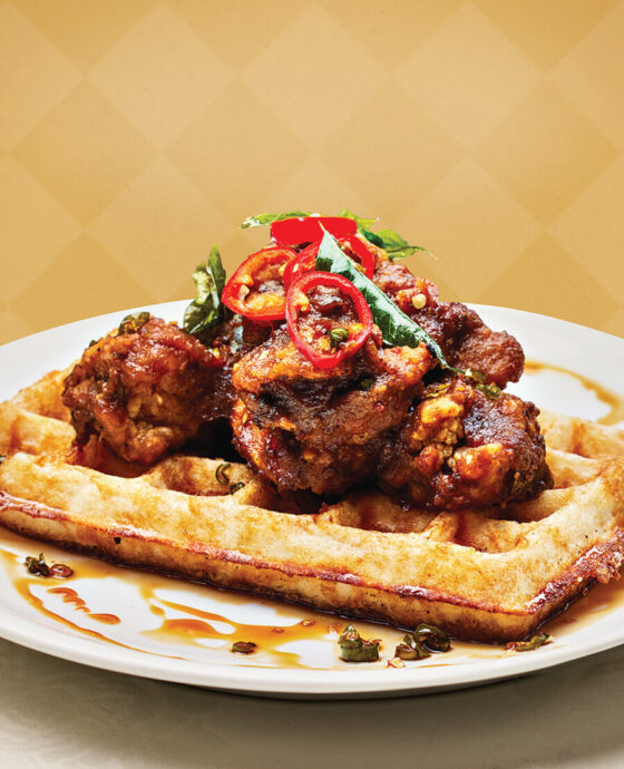 Chettinad-style chicken and dosa waffle, which features masala-coated fried chicken and toasted chili-jaggery syrup at Cheeni.