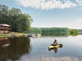 Person fishes from a kayak outside of the Lakeside Grill at Lake Holt