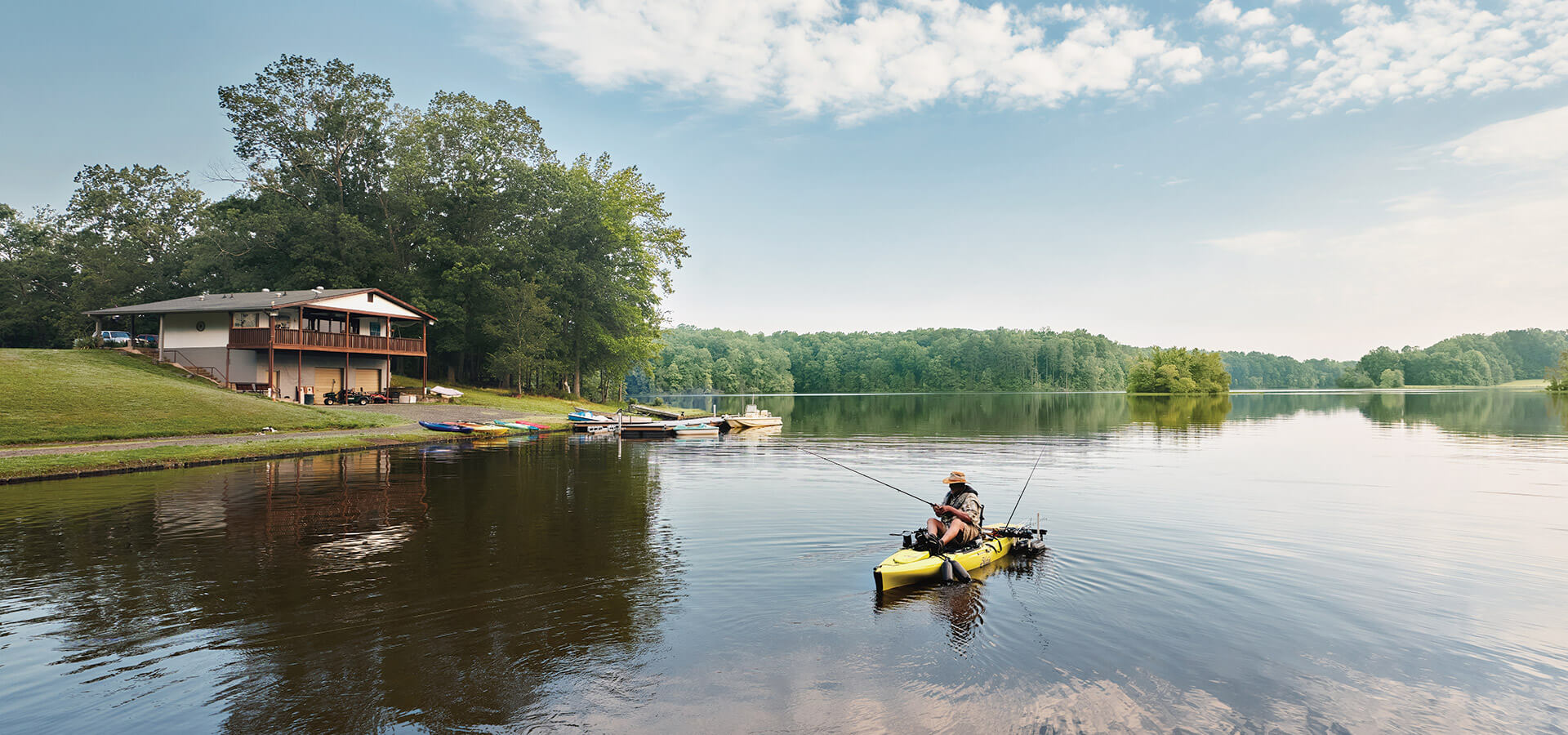 Person fishes from a kayak outside of the Lakeside Grill at Lake Holt