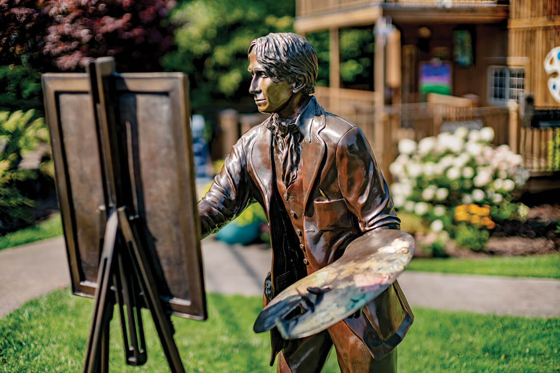 A sculpture of the artists stands outside of his former Edgewood Cottage.