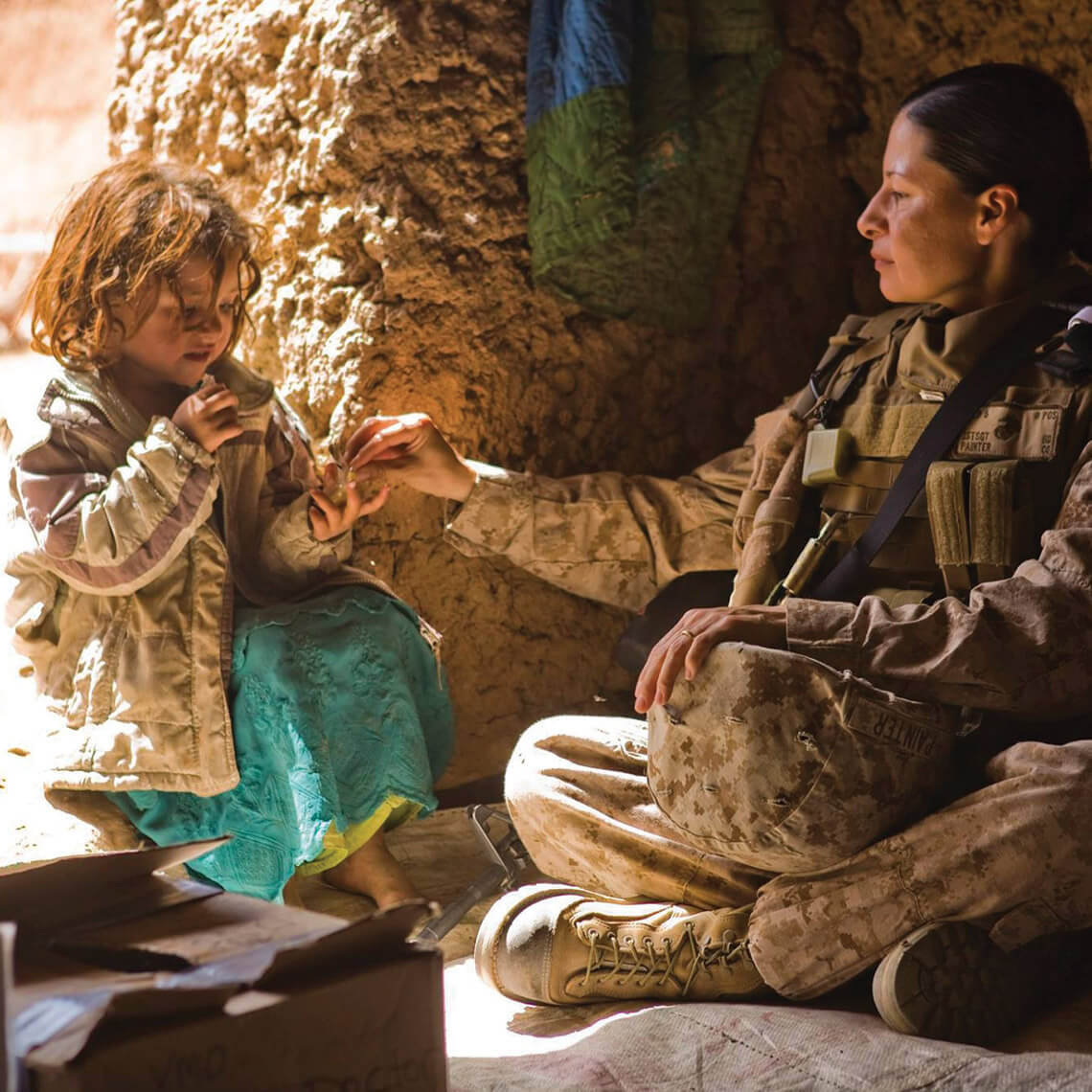 Painter giving candy to a little girl in Afghanistan.