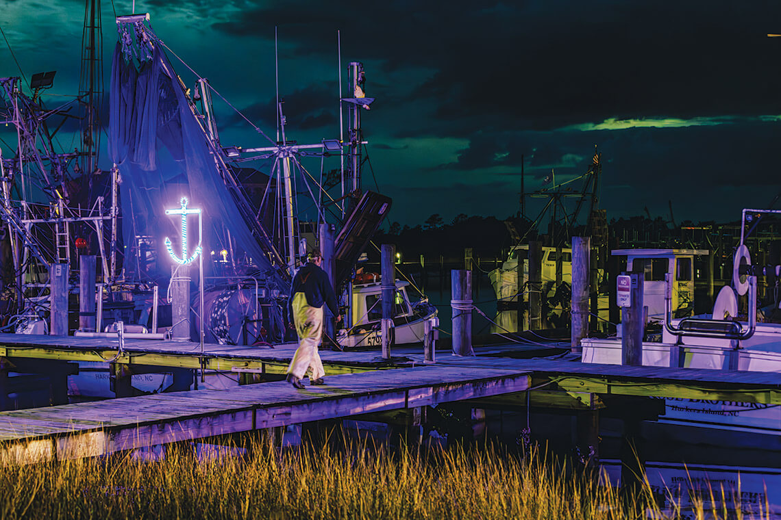 Harkers Island Boat Harbor at night with a glowing anchor
