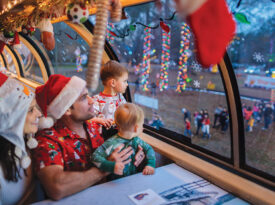 Family peers through the window while riding on the Carolina Christmas Train