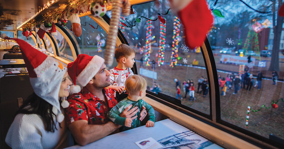 Family peers through the window while riding on the Carolina Christmas Train