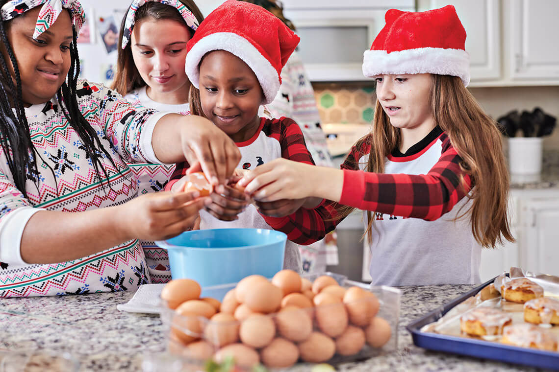 Girls crack eggs for a holiday brunch