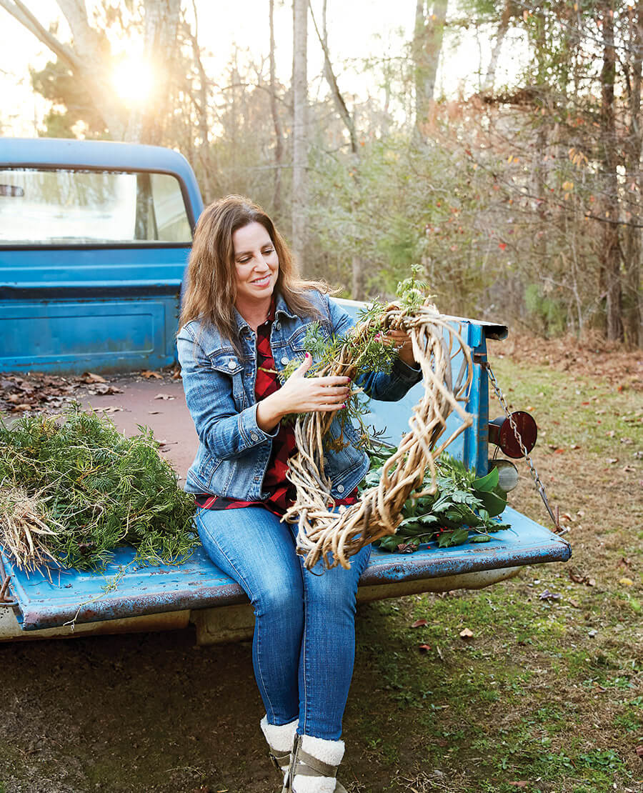 The author weaves a Christmas wreath in the bed of the pickup truck
