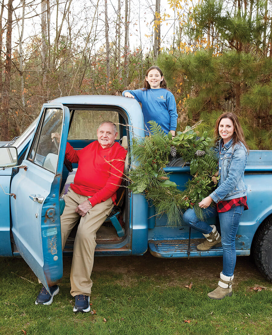 The author, Truett Haywood, and Peyton hold their foraged findings around the blue Chevrolet truck