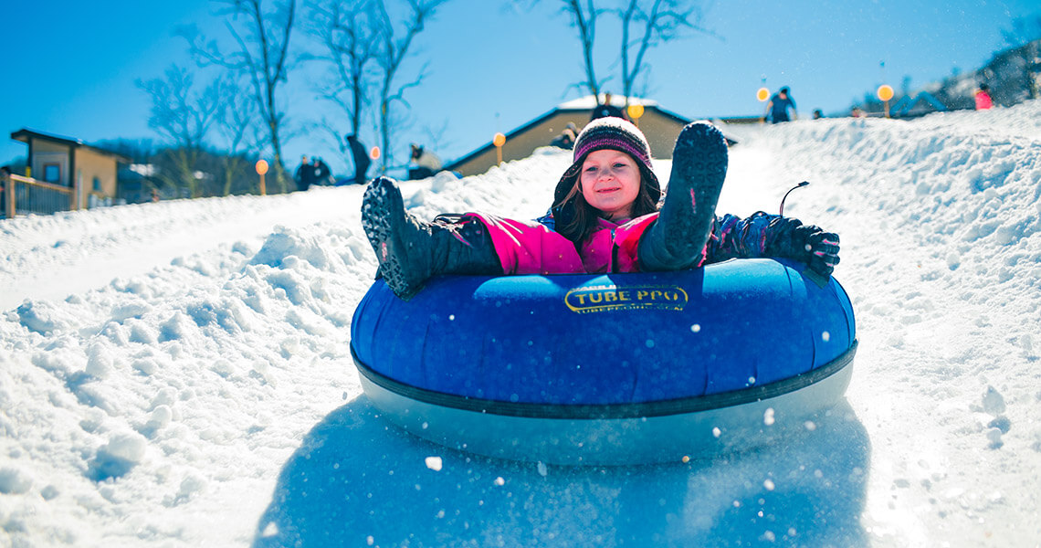 Little girl snowtubing at Beech Mountain ski resort near Boone, NC