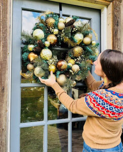 Woman hanging wreath outside Matthew Kelly's studio