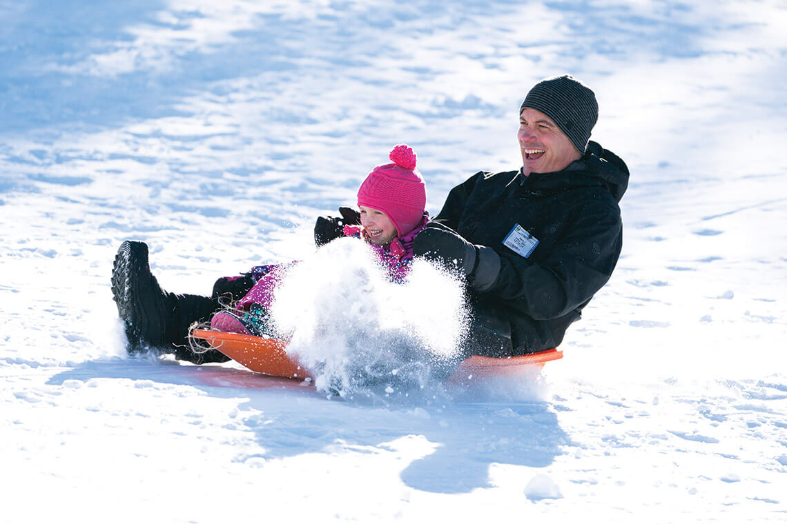 Father and daughter sledding at Beech Mountain