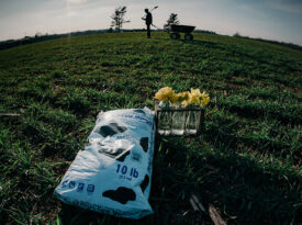 Bag of Daddy Pete's Plant Pleaser soil in a pasture