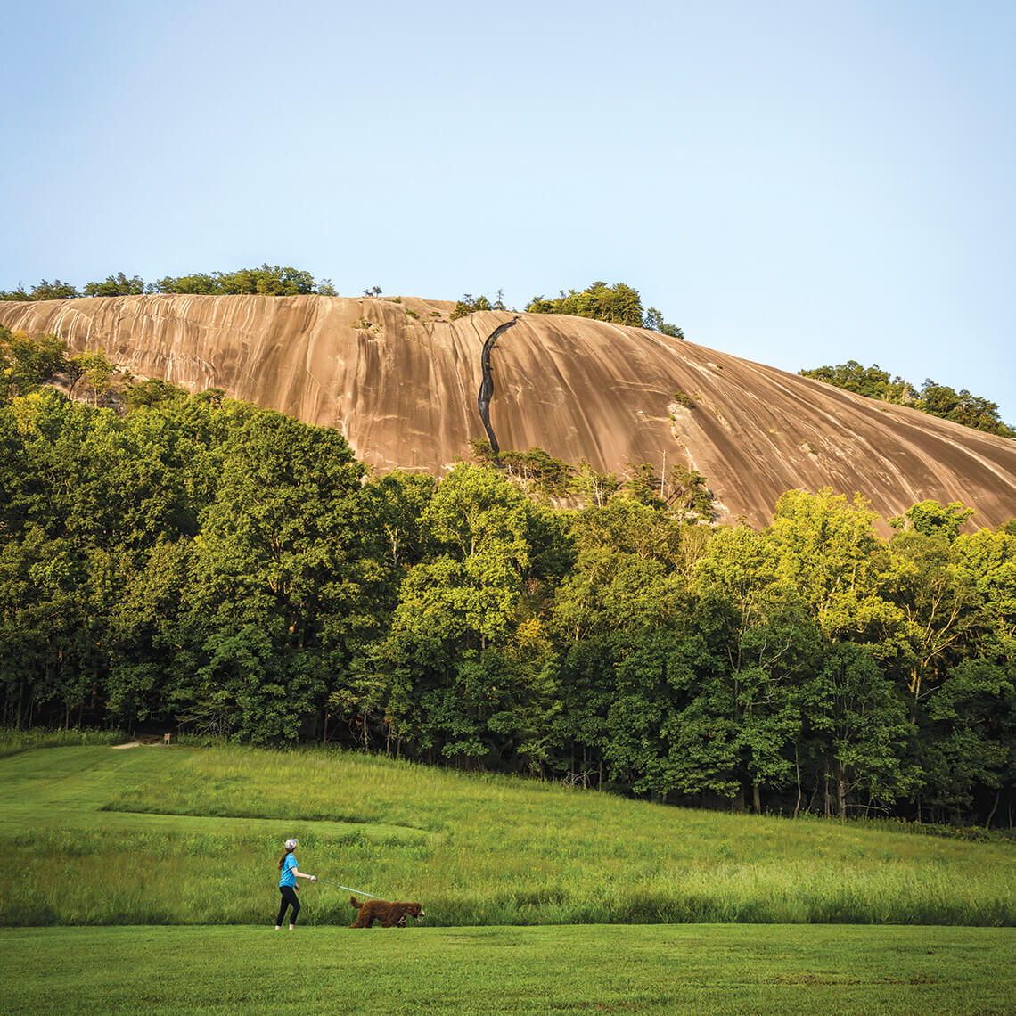 Hiker walks dog at Stone Mountain State Park