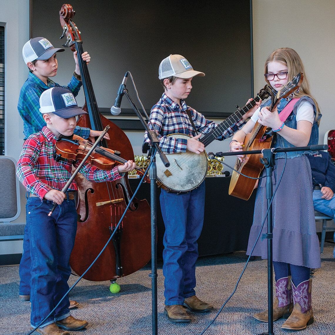 Children play fiddles, bass cellos, banjos, and guitars at the Tommy Jarrell Celebration Youth Competition 