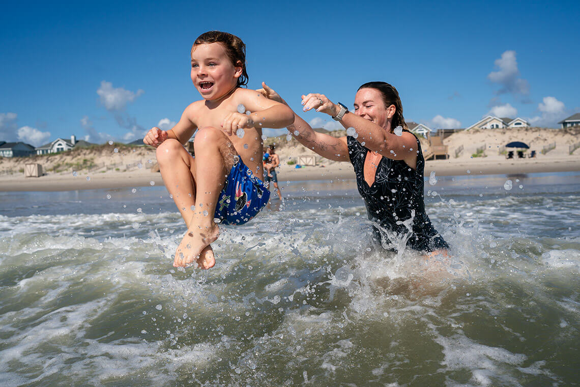 Mom and child playing in the ocean at Corolla