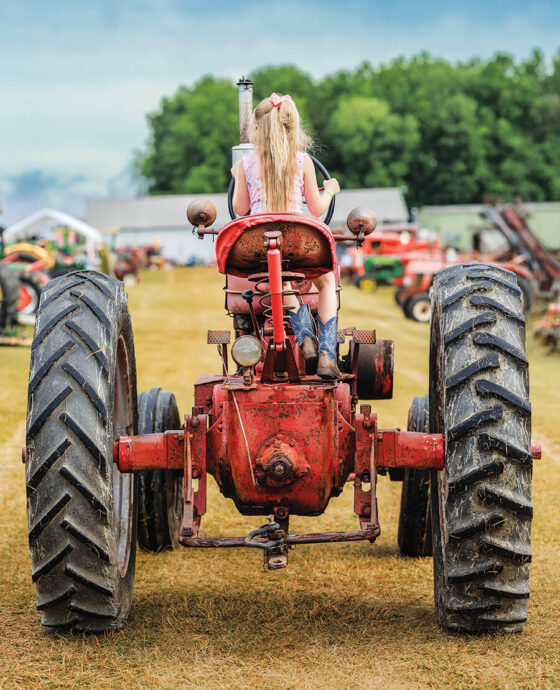 Child driving tractor at Southeast Old Threshers Reunion in Denton