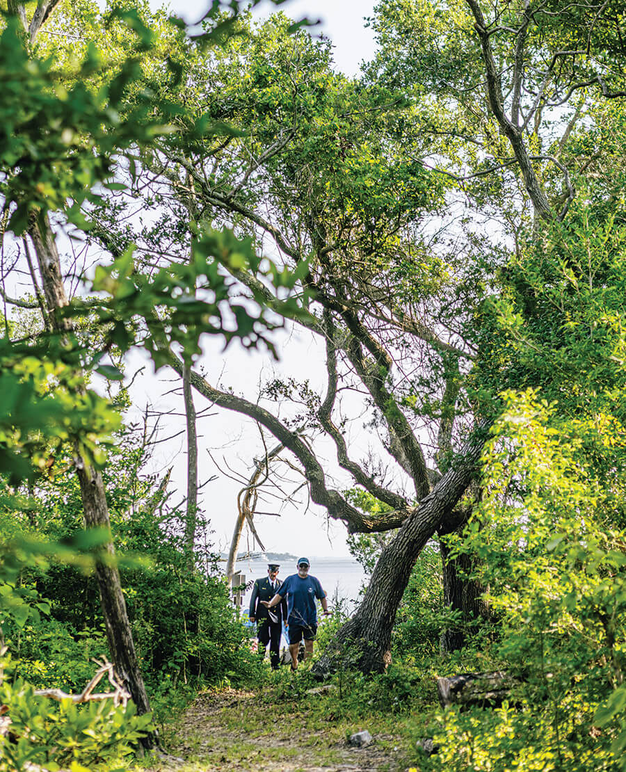 Chris Yeomans and Heber Guthrie walk along a wooded trail