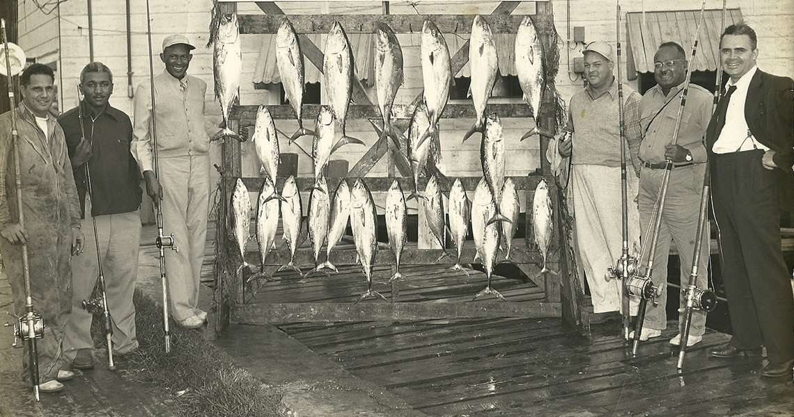 Black and white photo of Ocean City vacationers showing off their caught fish
