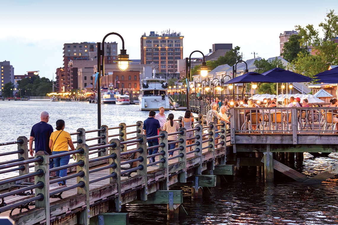 People stroll Wilmington's Riverwalk during the evening