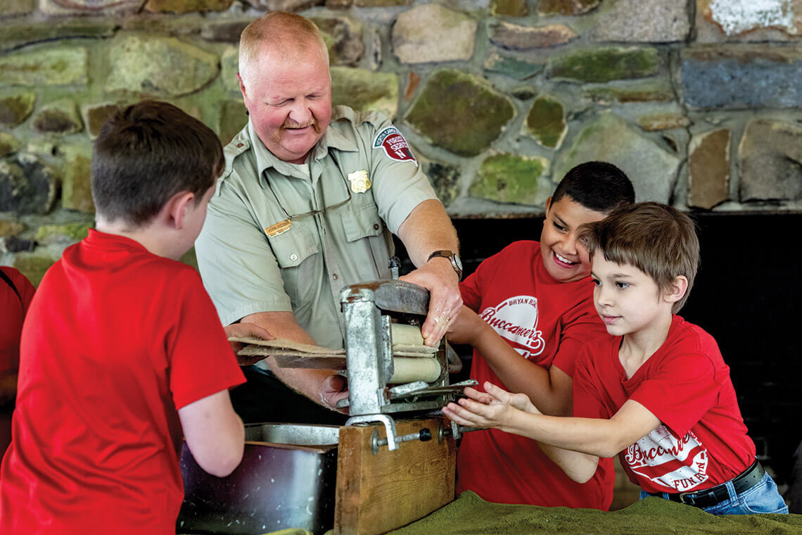 Pittman and students practice processing a tree into paper