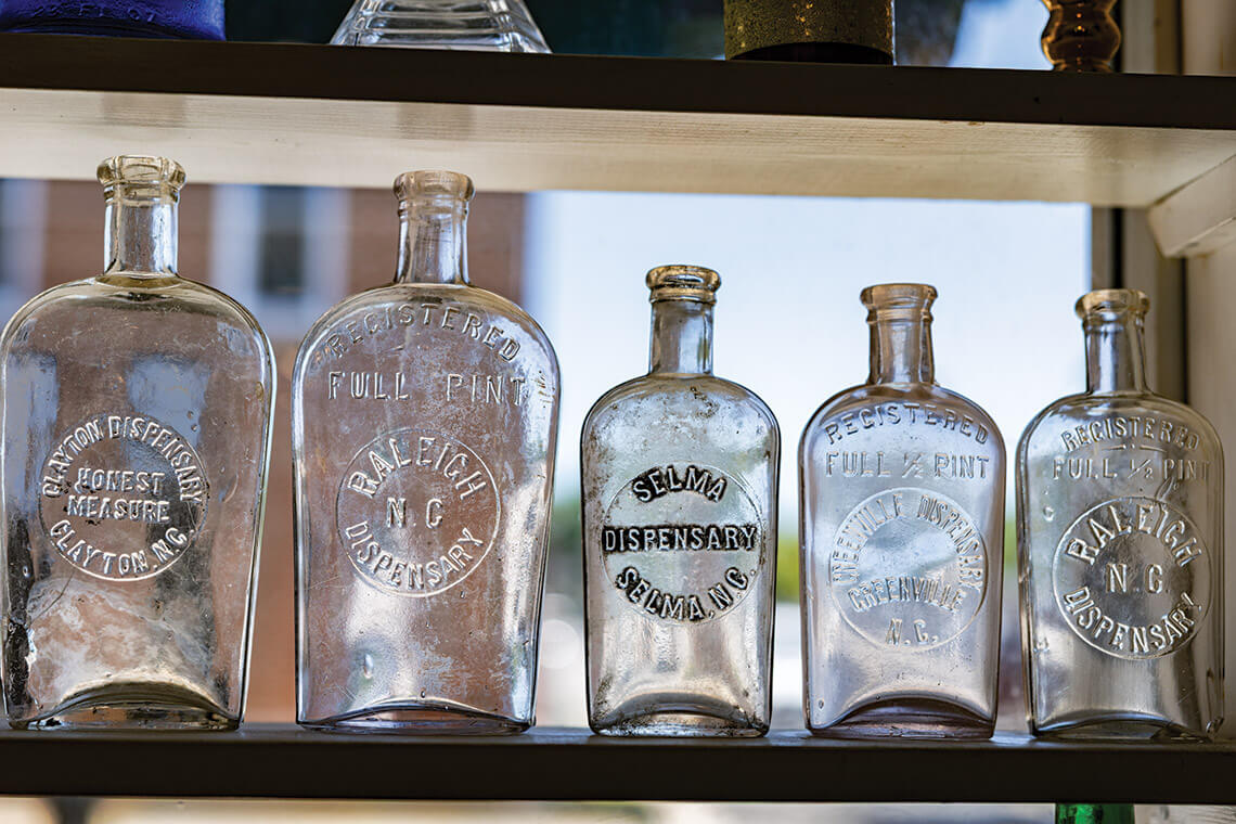 Old whiskey bottles on the shelf at Given's shop