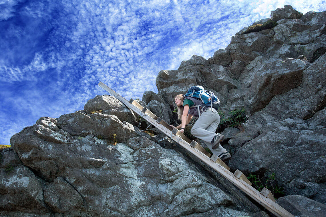 Hiker climbs the ladders on Grandfather Trail