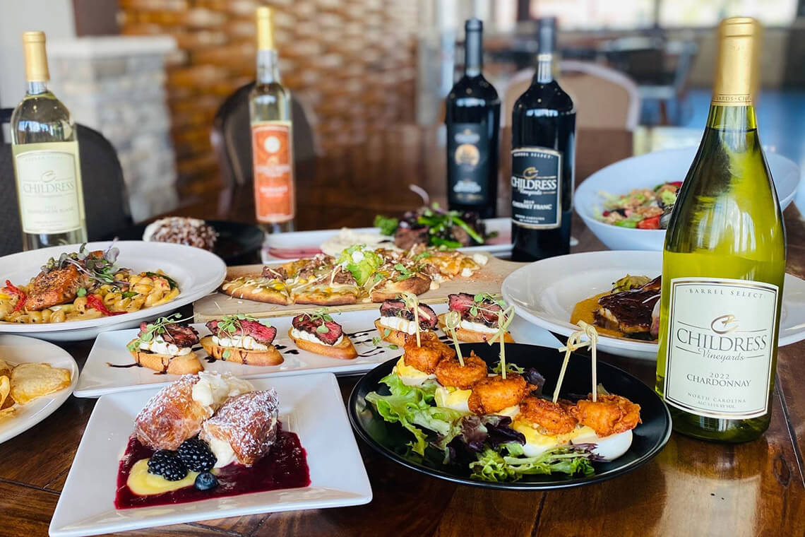 Bistro at Childress Vineyards with food surrounded by bottles of wine.