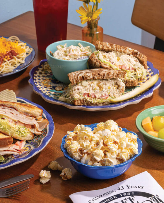 Table with assorted sandwiches and side of popcorn at Three Chopt Sandwich Shoppe in Hendersonville