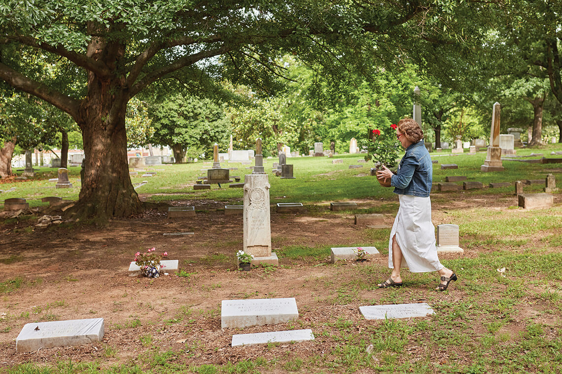 Laura Allred walks among the gravesites