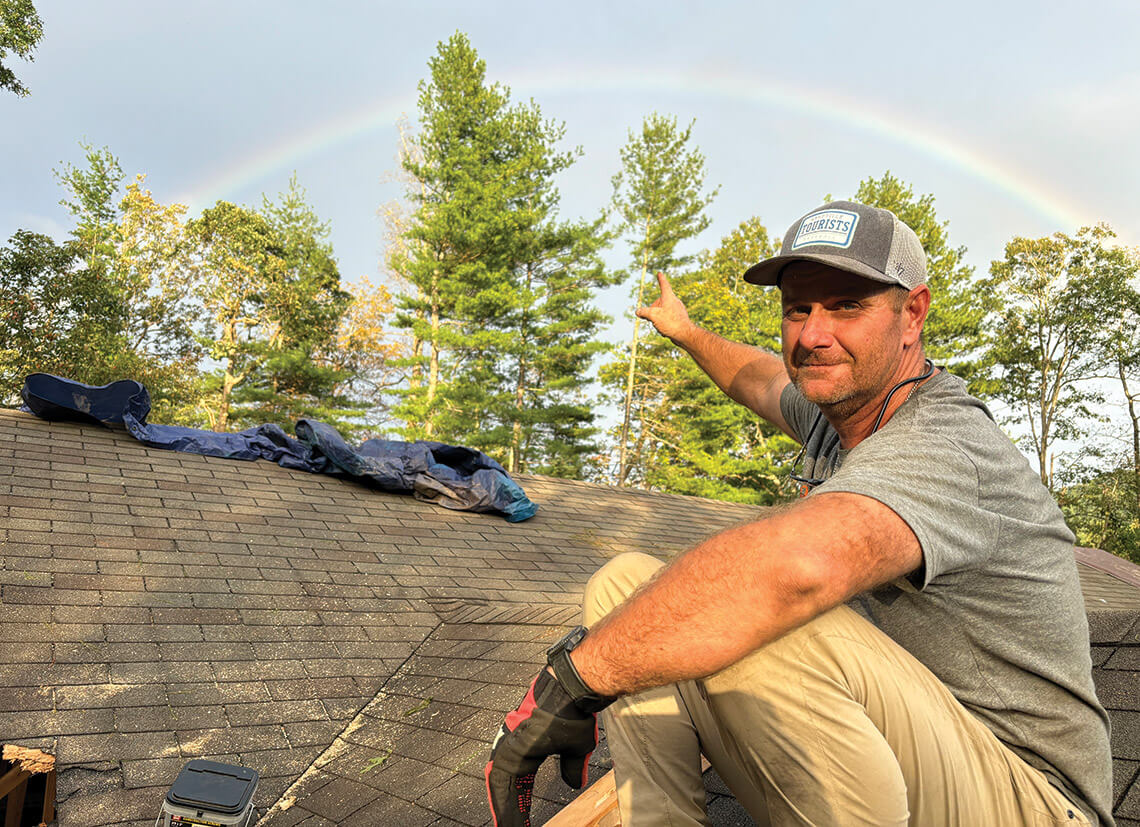 Jerry Owensby pointing to a rainbow