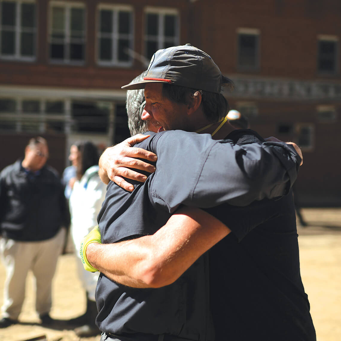Former governor Roy Cooper hugs Josh Copus in Madison County