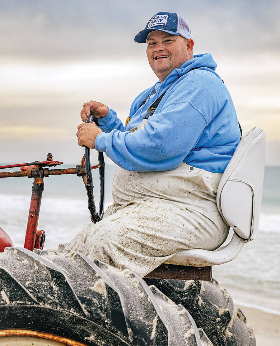 Chris Lewis drives a tractor for the crew of seine fishermen