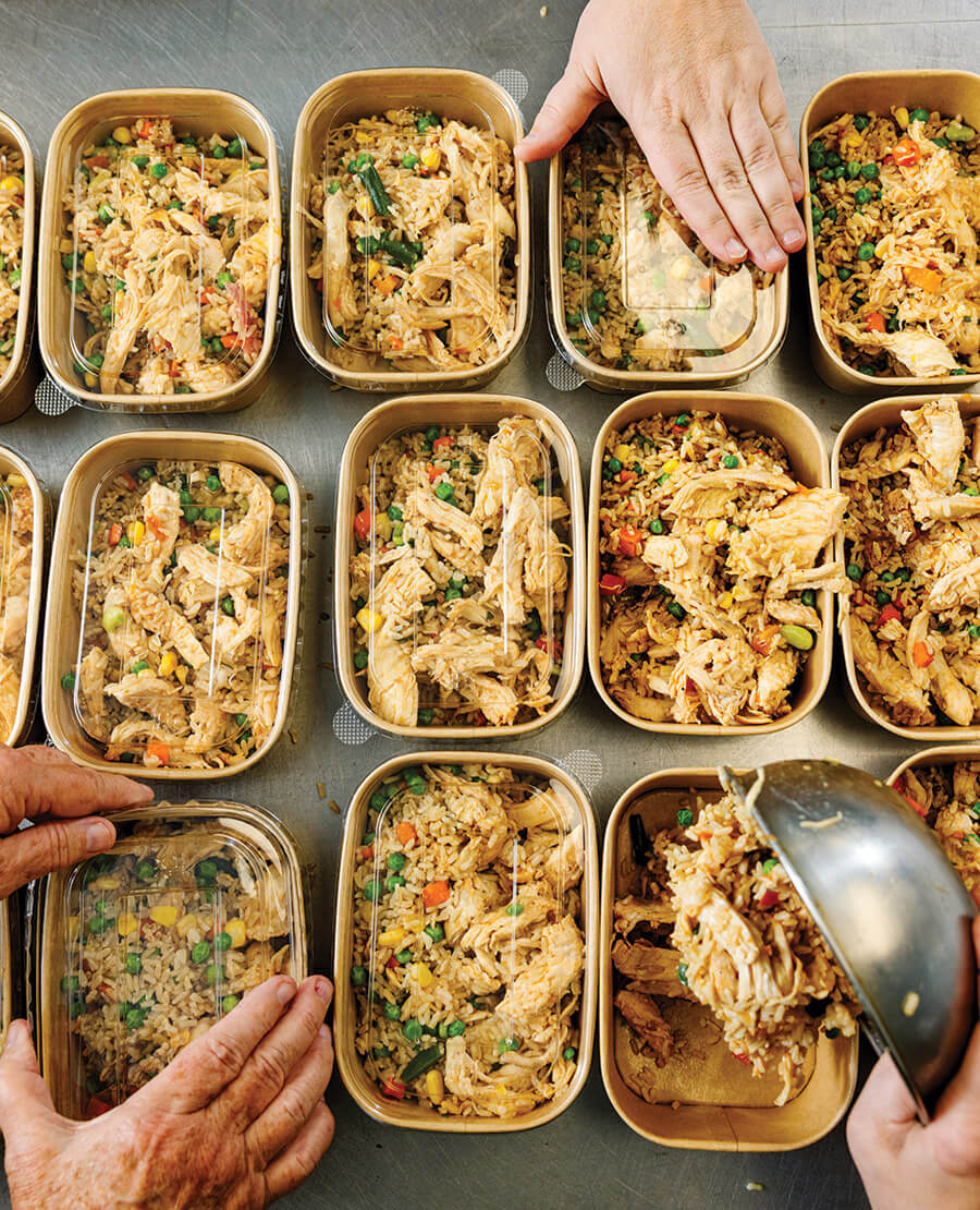 Volunteers prepare meals for Feed-Well Fridges. 