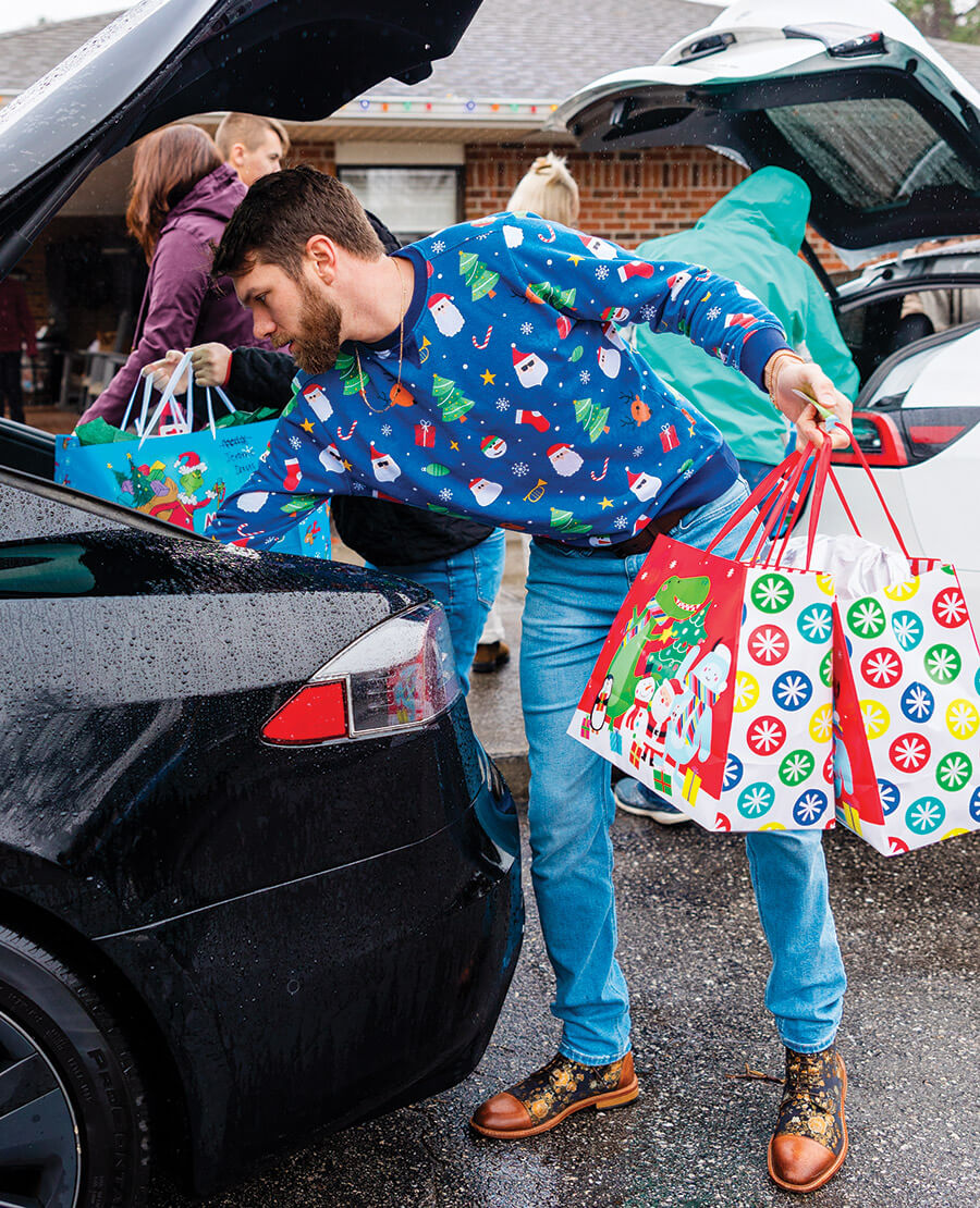 Nick Newell unloads Christmas presents from his car to deliver to recipients in the community