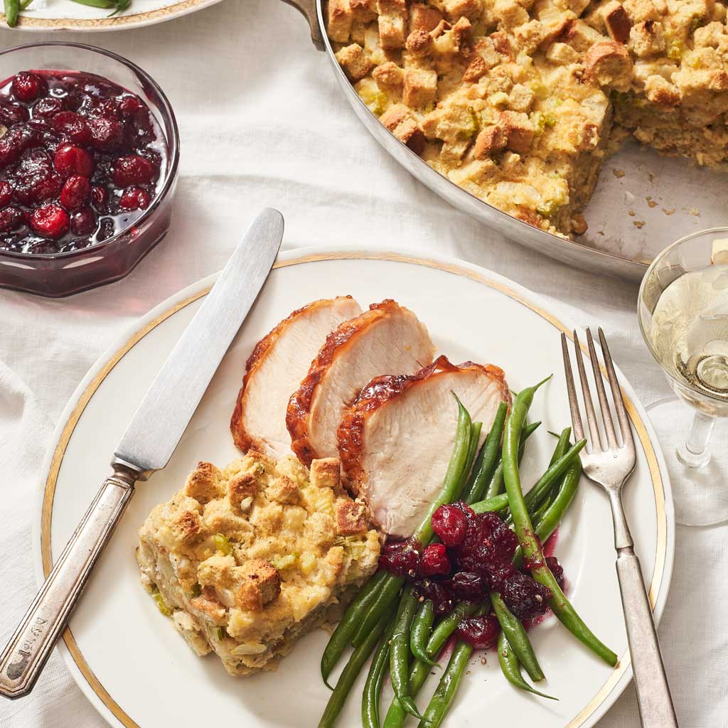 Plate of turkey, dressing, green beans, and cranberry sauce