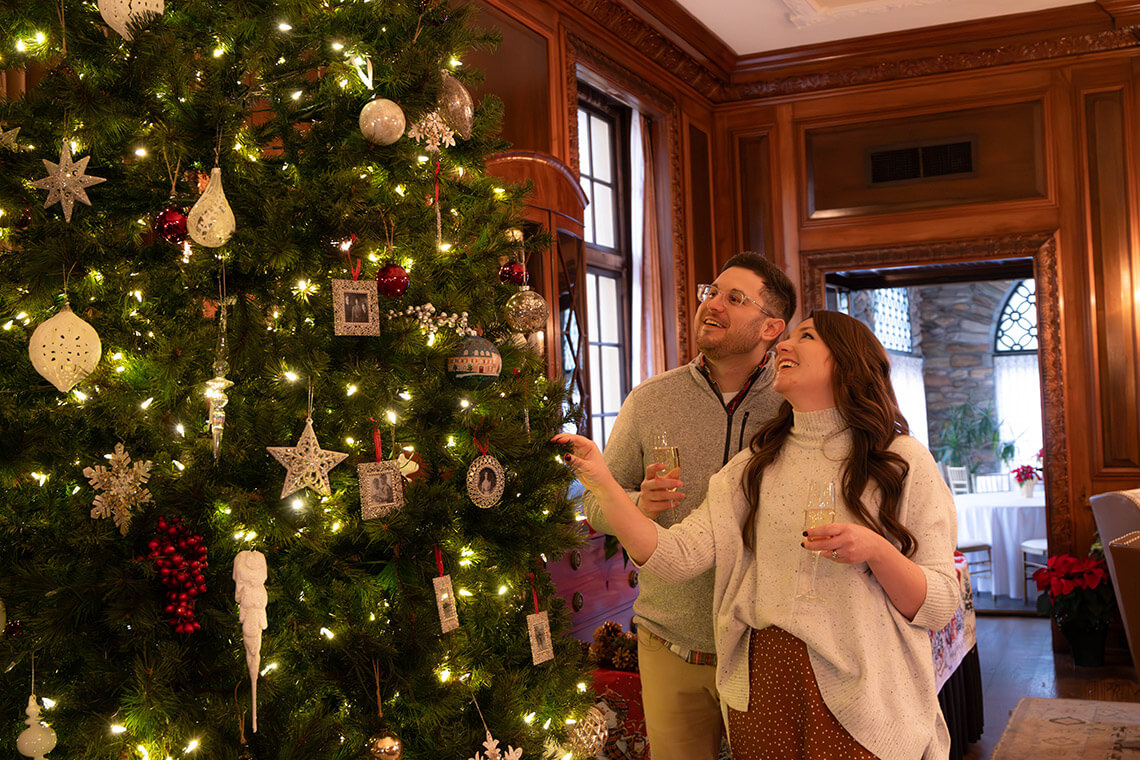 Couple admires Christmas decorations on the tree at Graylyn