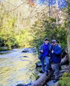 Two hikers give a thumbs up by the river
