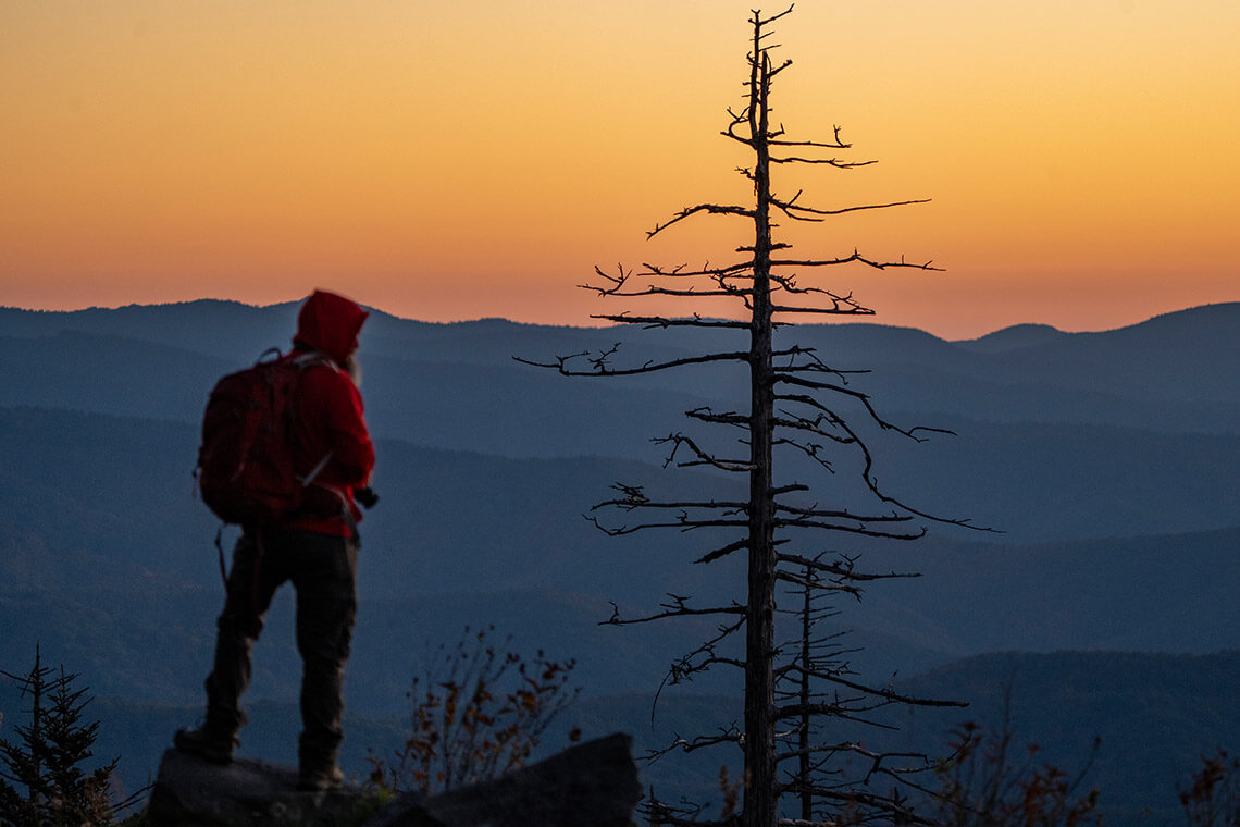 Hiker overlooks mountain vista