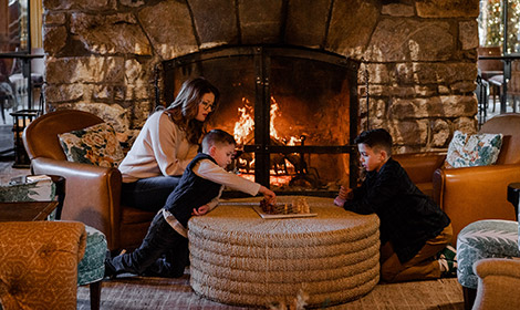 Family sitting around fire playing chess